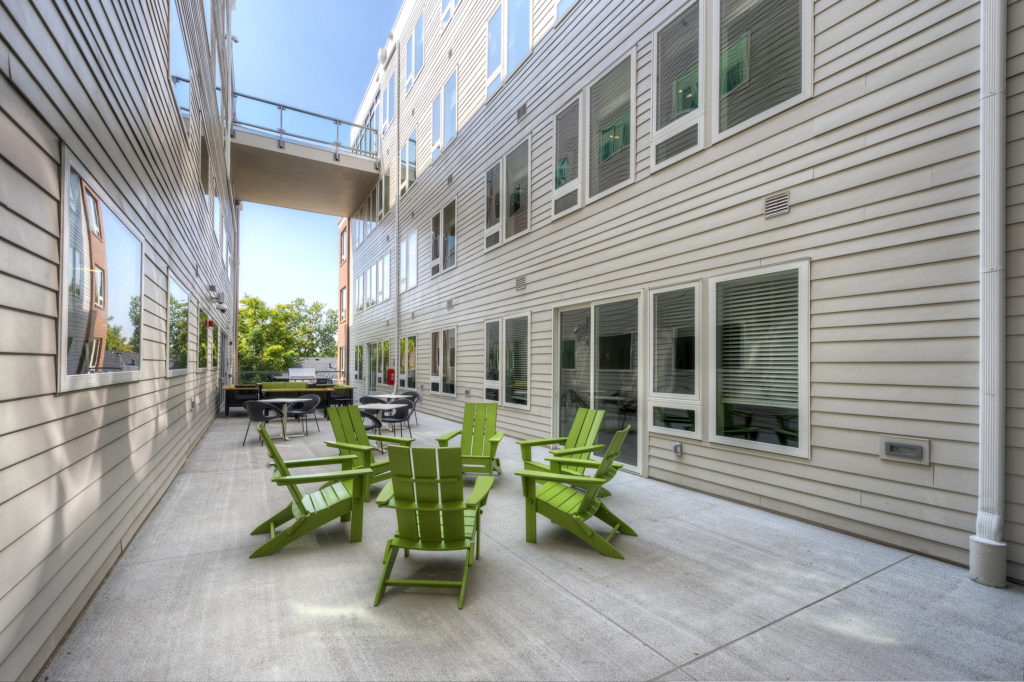 apartment courtyard with Adirondack chairs and gas grill 